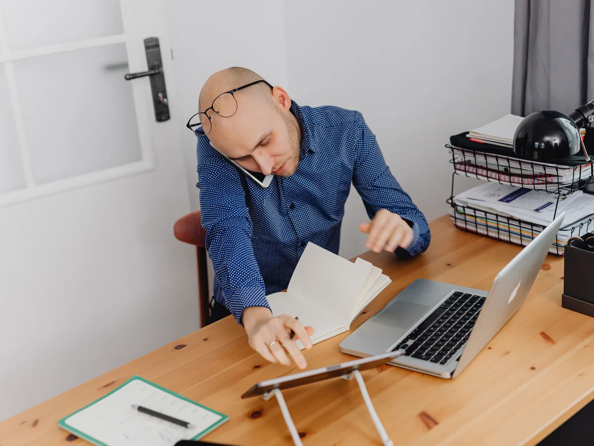 Publisher planning an advertising setup beside a laptop and notebook