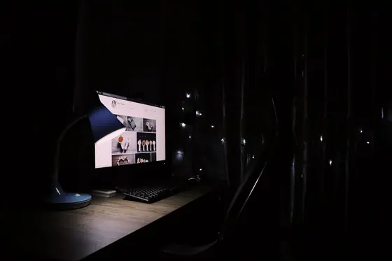 A monitor glowing in a dark room, the setting where blacks that look gray on a monitor are most obvious