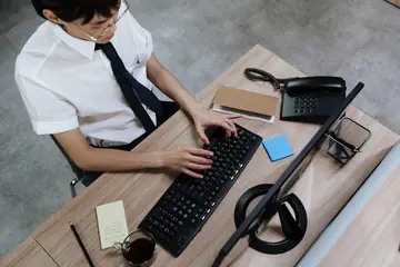 A person at a desk typing on a slim wireless keyboard, the setup where Bluetooth keyboard lag shows up most