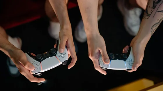 Two players holding PS5 DualSense controllers, ready for a controller stick drift test