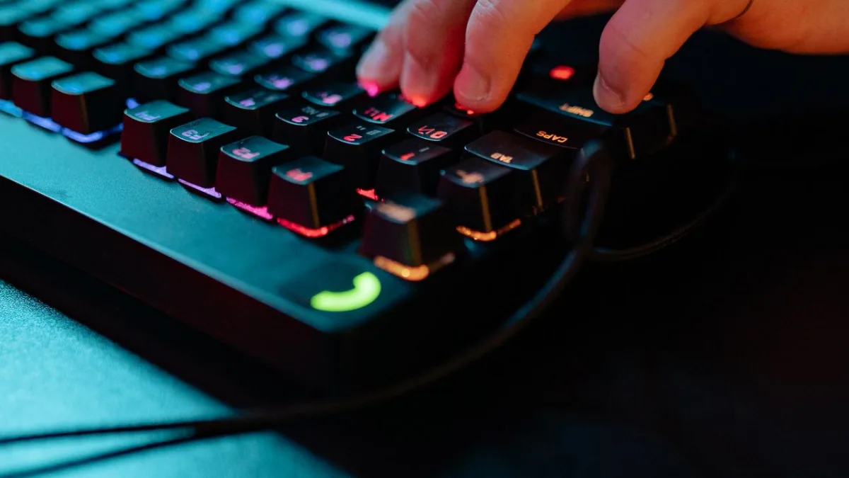 Gros plan de doigts appuyant sur les touches d'un clavier mécanique RGB