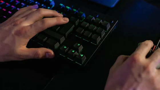 FPS player using a mouse and keyboard while comparing TTK and DPS