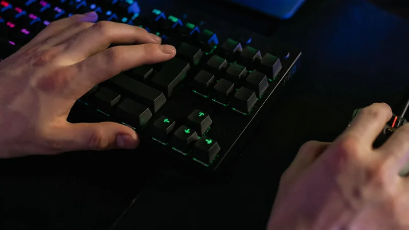 FPSプレイヤーがキーボードとマウスを使いながら武器のTTKとDPSを比較している場面