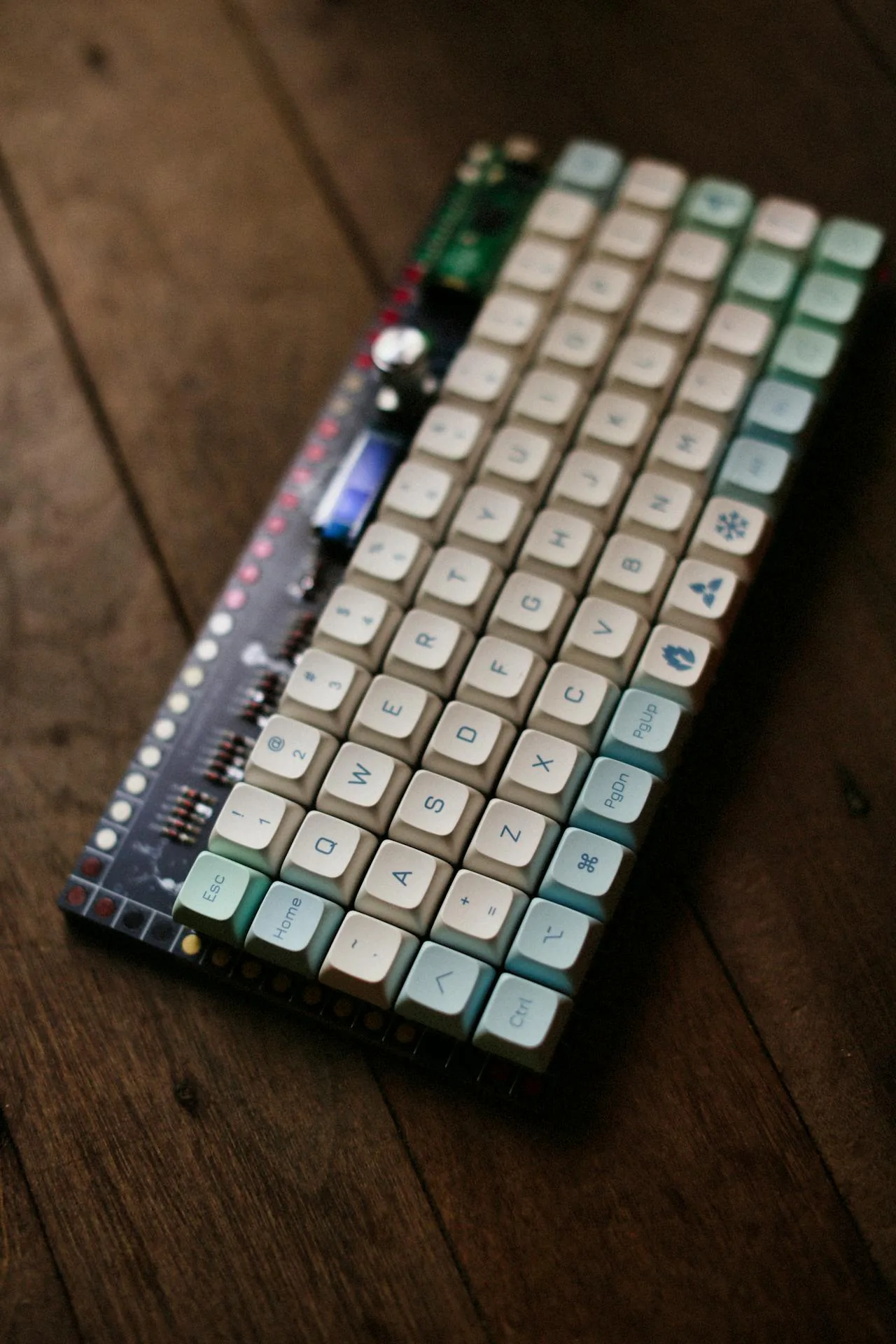 Close-up of a custom mechanical keyboard with colourful keycaps on a wooden surface — the kind of boutique keyset enthusiasts pair with a V4N4G0N 45% case