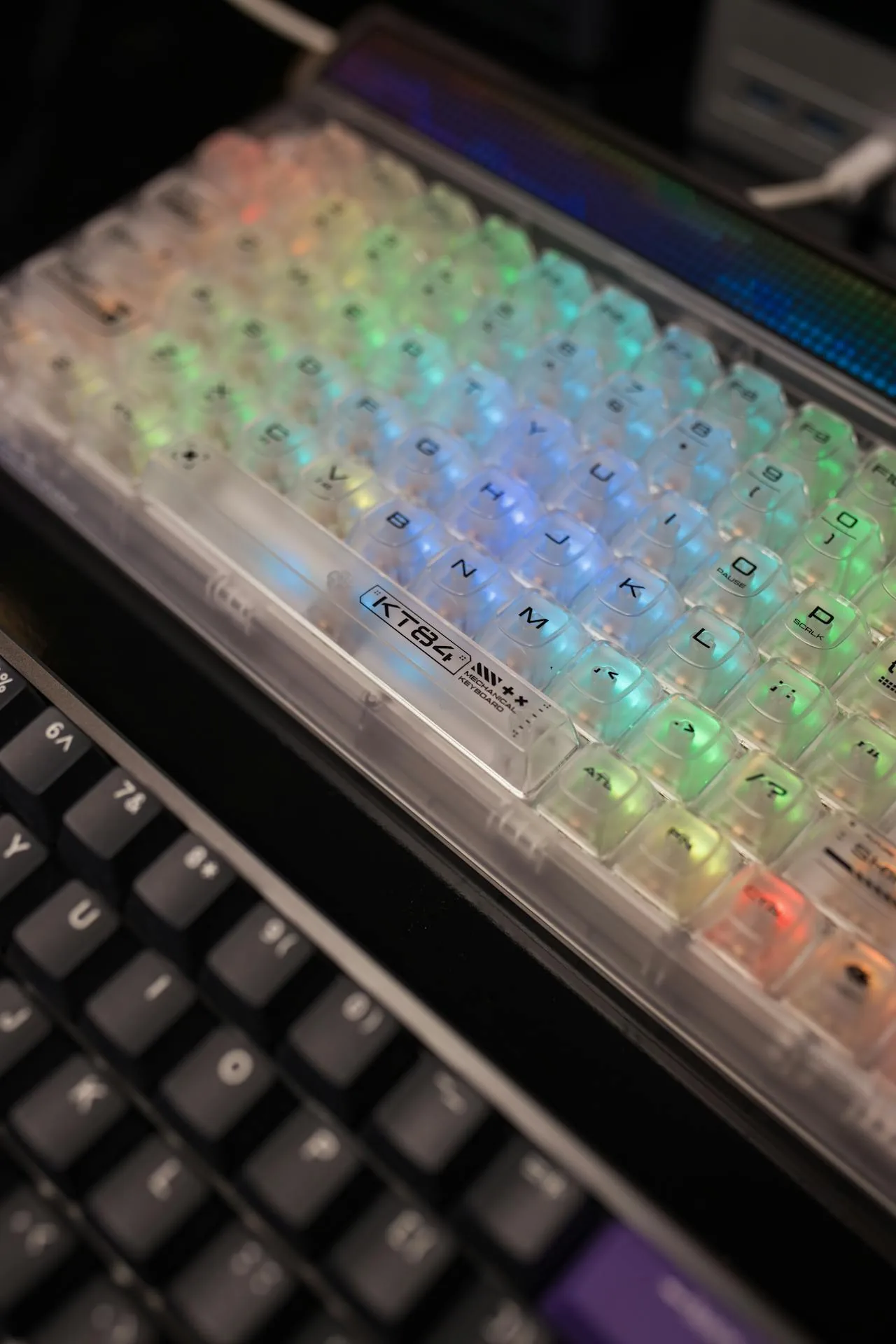 Close-up of a transparent compact mechanical keyboard with vibrant RGB lighting — representative of the boutique 45% custom keyboard aesthetic the V4N4G0N popularised