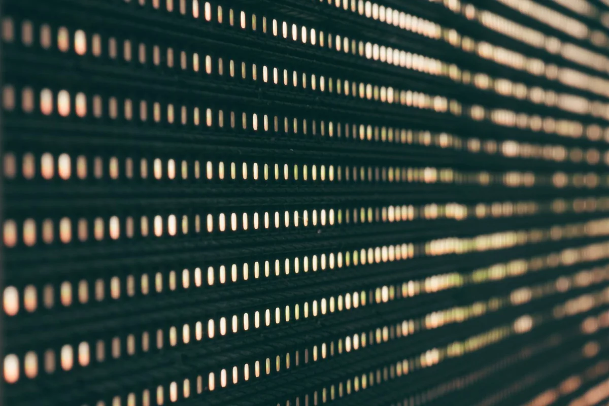 Extreme macro close-up of illuminated display sub-pixels showing the color layout behind text fringing