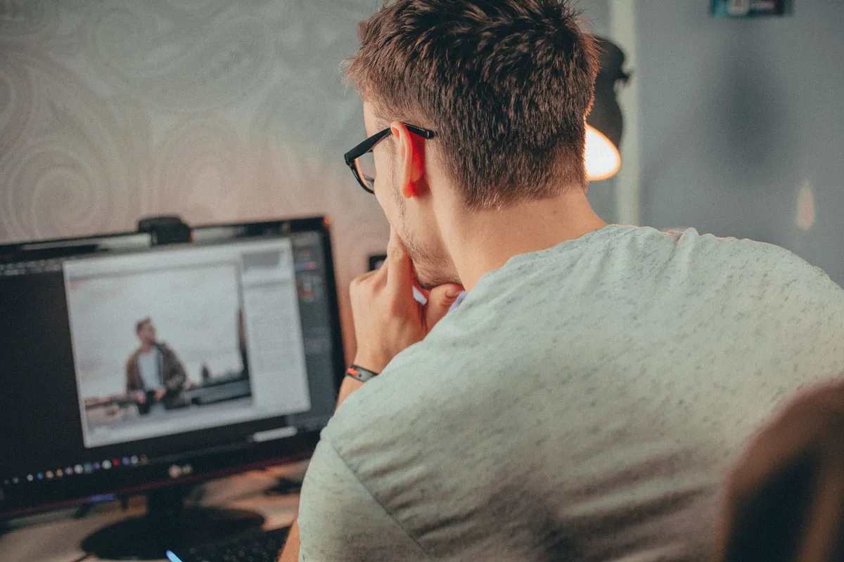 Person focused on a desktop monitor rechecking text and edges after fixing a blurry display