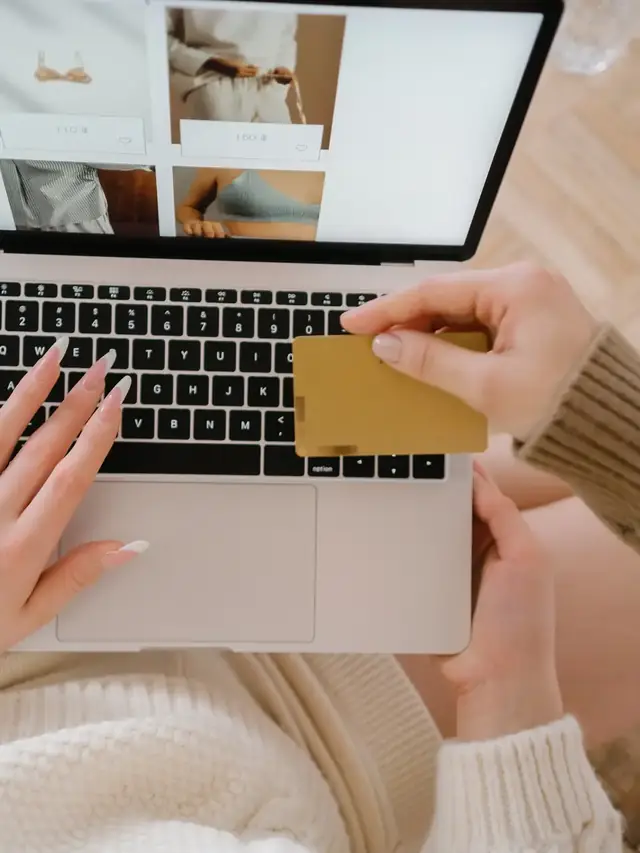 Hands reviewing product information and payment details on a laptop