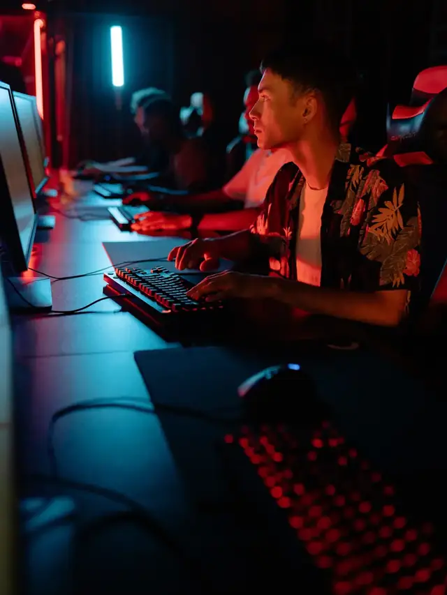 Gamer watching a monitor while pressing keys at an esports desk