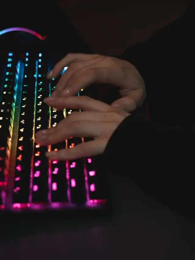 Hands holding several keys on an RGB mechanical keyboard