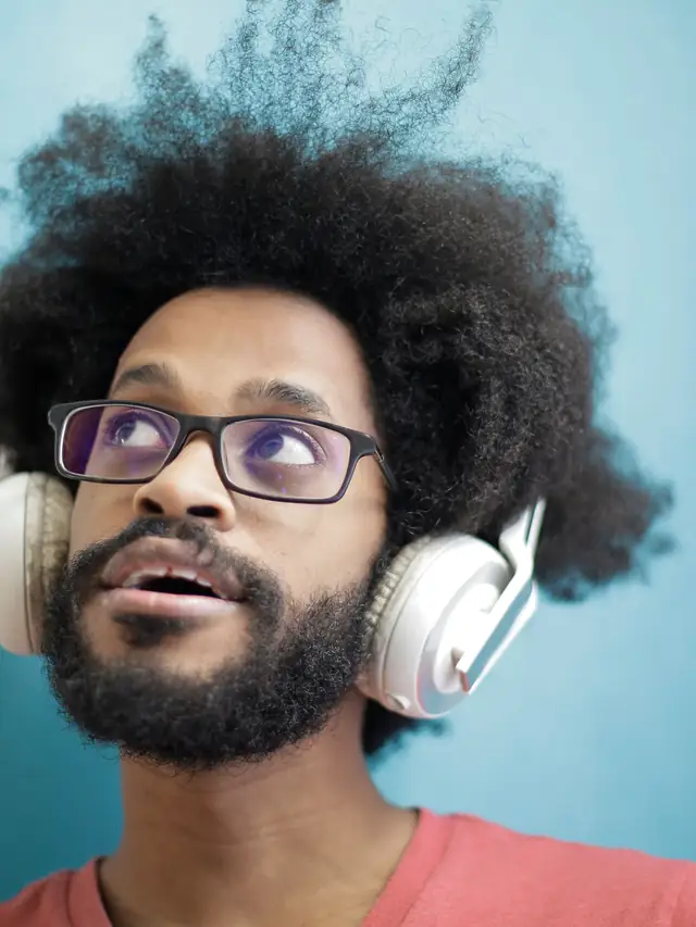 Man wearing headphones looking upward while listening