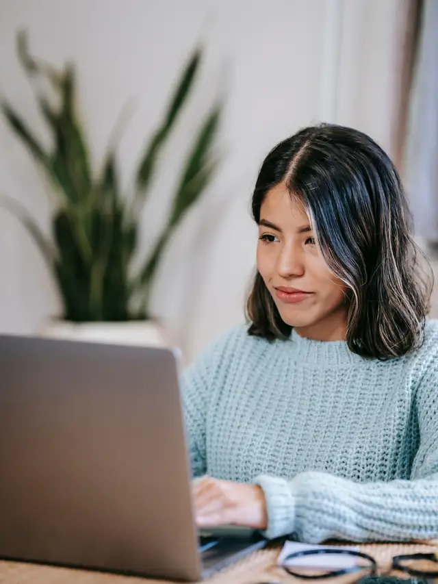 Woman using a laptop at a home desk