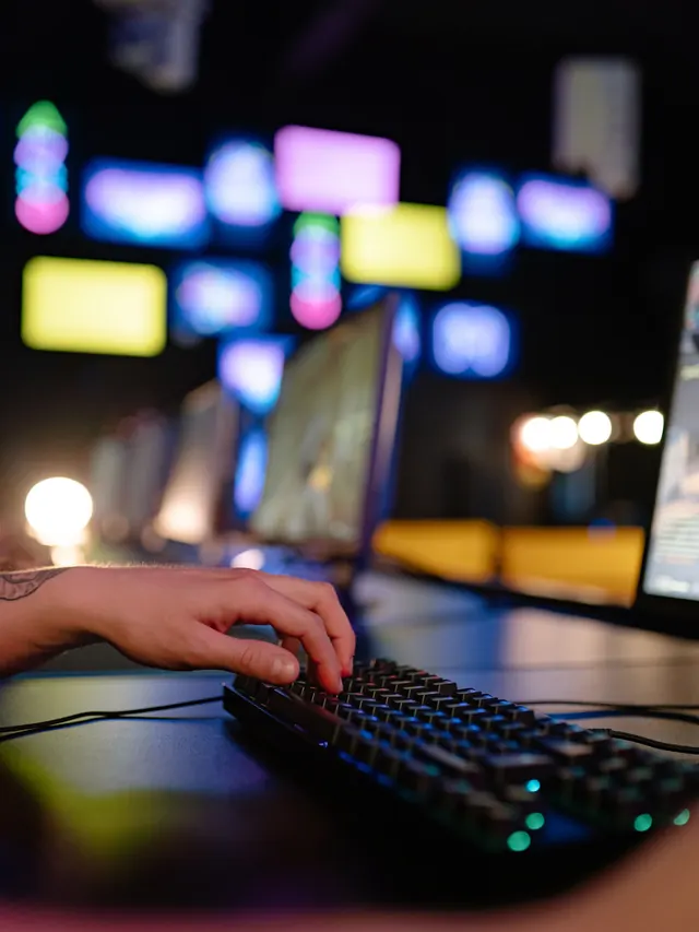 Hand using a compact mechanical keyboard in a gaming room