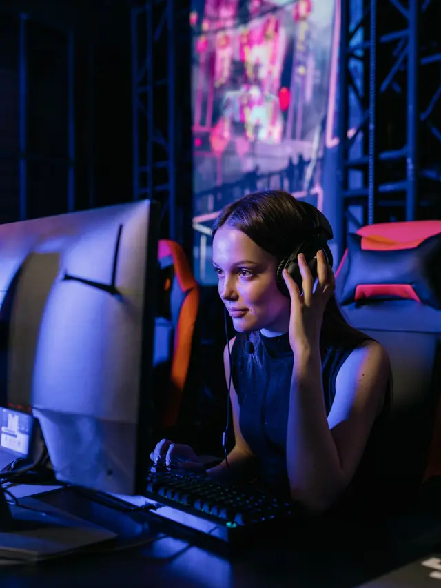 Focused woman gaming at a neon-lit desktop; illustrative stock photo, not a Naga V3 Pro user