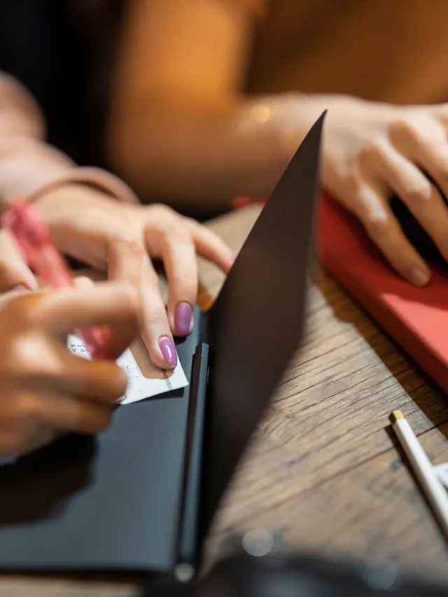 Person taking notes while using a generic mouse; illustrative photo