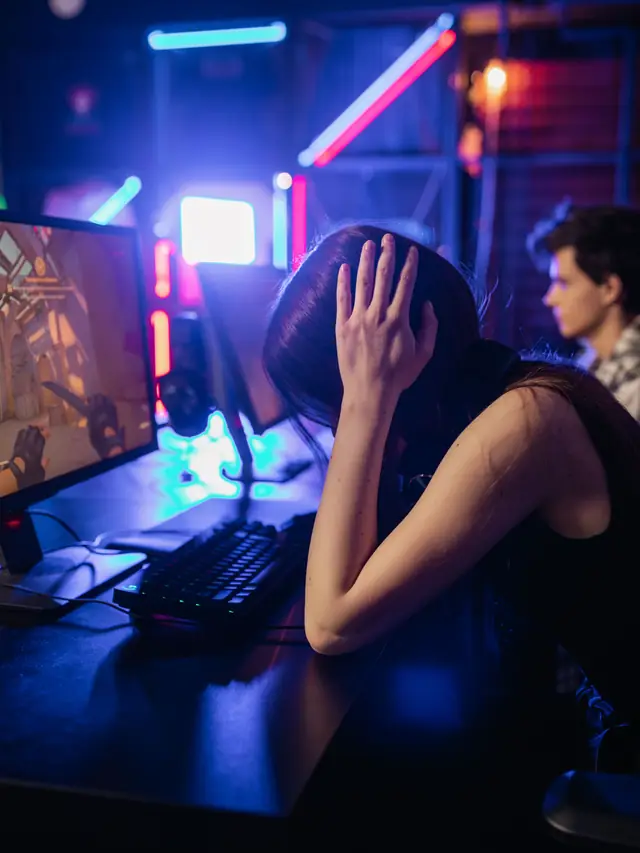 Woman reacting at a gaming PC; illustrative stock photo, not a product user