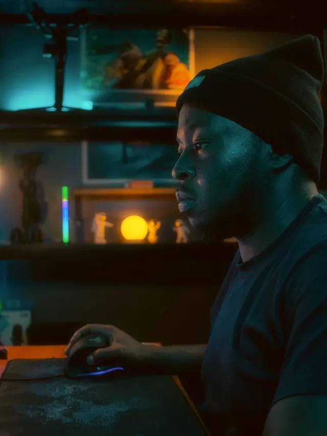 Man gaming with a generic mouse in a dark PC setup; illustrative photo