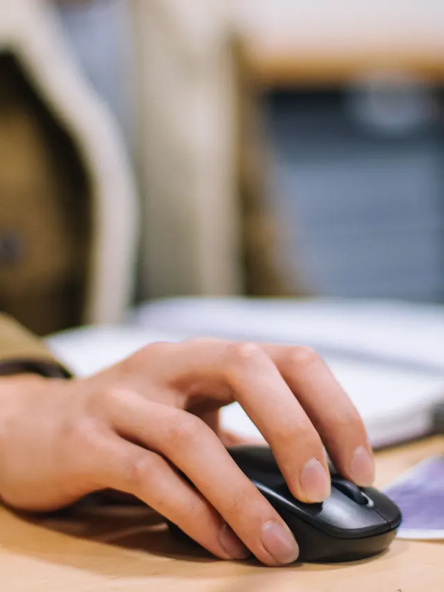 Hand using a generic wireless computer mouse; illustrative photo