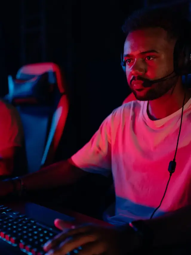 Gamer resting one hand on a keyboard while wearing a headset