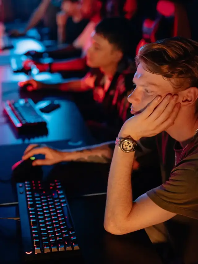 Gamer comparing hand position and keyboard reach at a gaming station