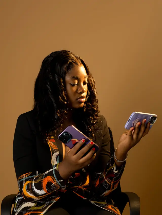 Woman comparing two smartphones while deciding which one to use