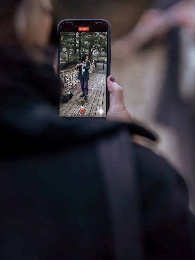 Person recording another person with a smartphone for a controlled camera comparison