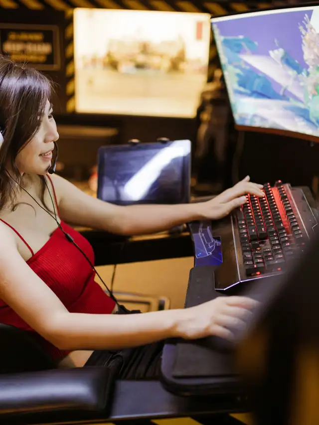Gamer in a red top reaching toward a mechanical keyboard