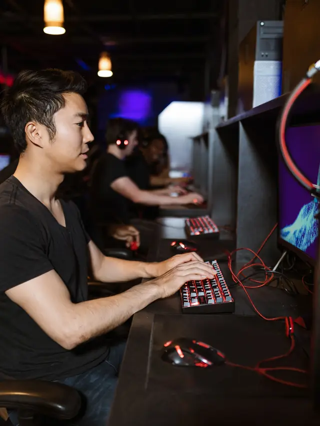 Focused gamer using a compact red-backlit keyboard and mouse