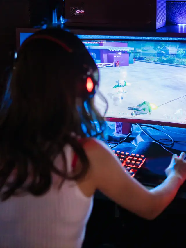 Headset-wearing gamer playing a competitive game at a keyboard