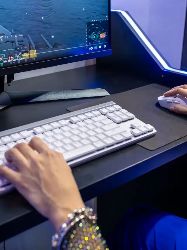 Hands using a white keyboard and mouse during a PC game; illustrative stock photo