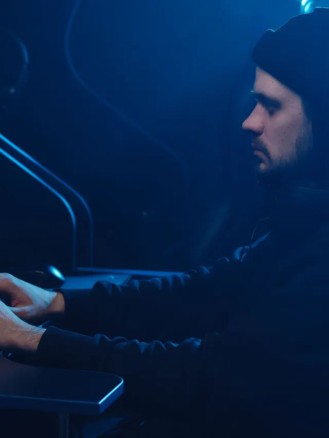 Bearded gamer typing at a blue-lit computer station; illustrative stock photo, not the reviewed Razer model