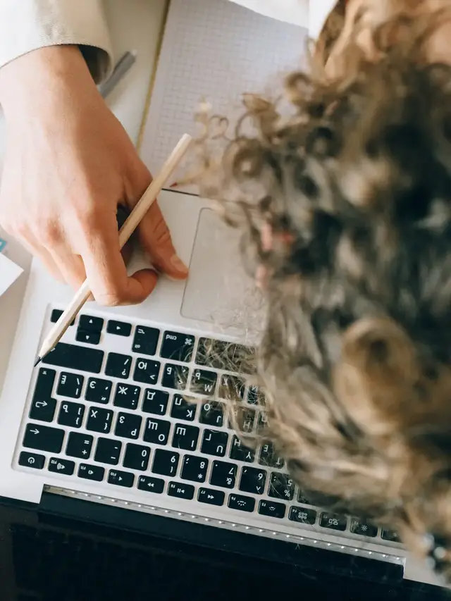 Person reaching toward a laptop keyboard during troubleshooting