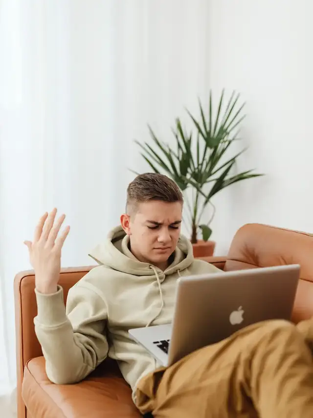 Frustrated laptop user raising one hand after a keyboard problem