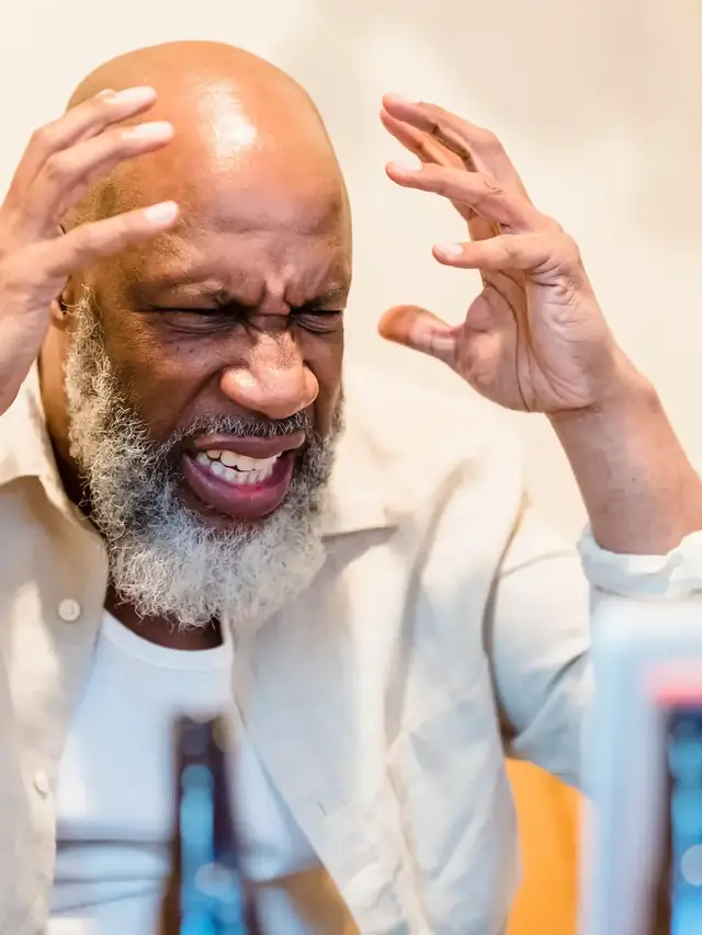 Frustrated man concentrating on a laptop at a table
