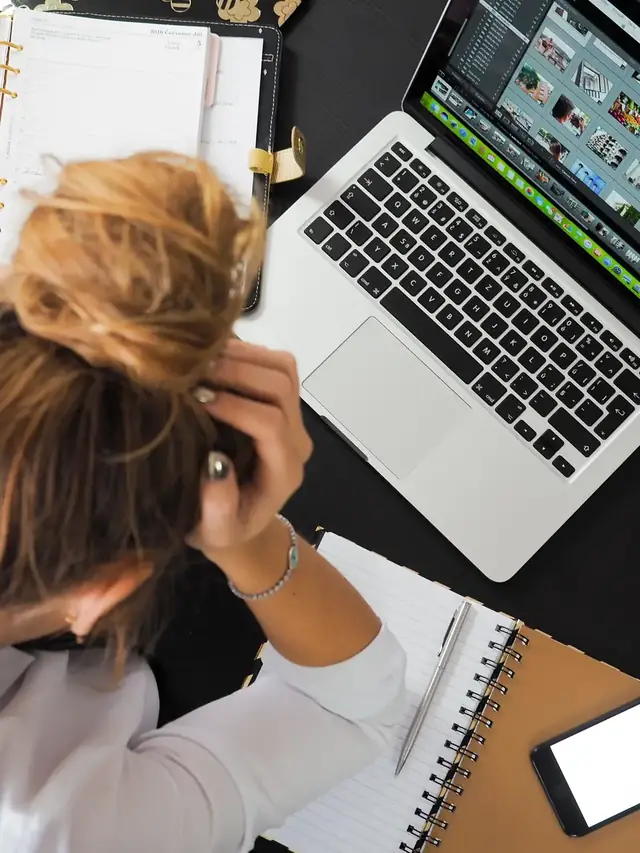 Person comparing a laptop with other devices at a desk