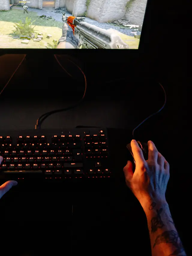 Hands operating a mouse and keyboard during a game; stock illustration of checking current controls