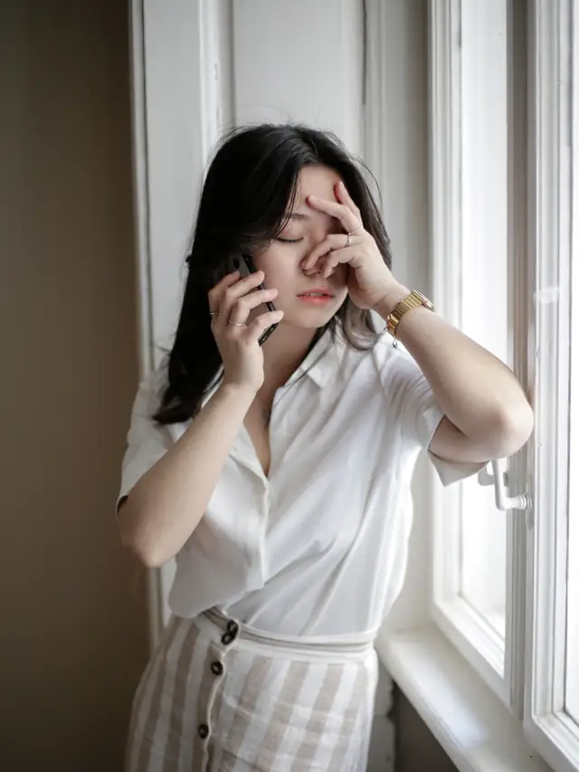 Woman by a window looking frustrated during a phone call
